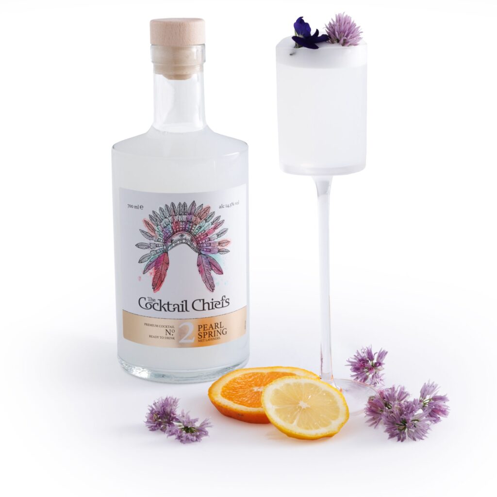 Close-up van de Pearl Spring cocktail met een lichte, etherische kleur, een glanzende vegan schuimlaag en een lavendeltakje als garnituur.