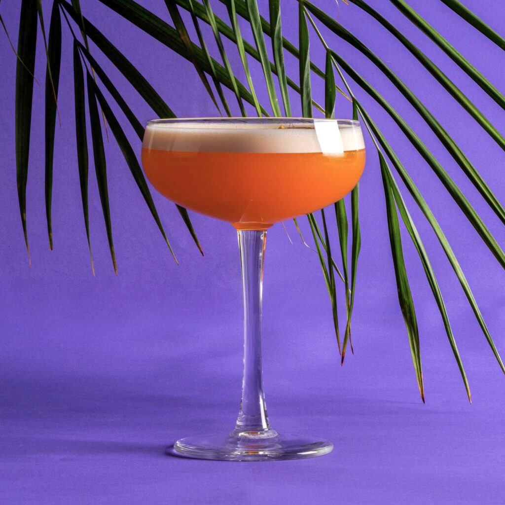 Pornstar Martini in martiniglas met schuimlaag en passievrucht – tropische cocktail serveerfoto